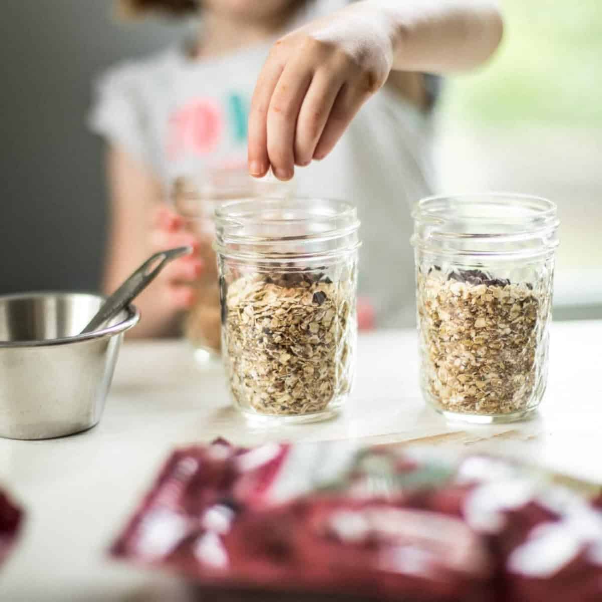 little girl adds a topping to her oatmeal