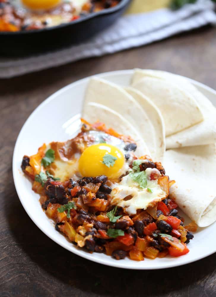 Huevos Rancheros and tortillas on a white plate