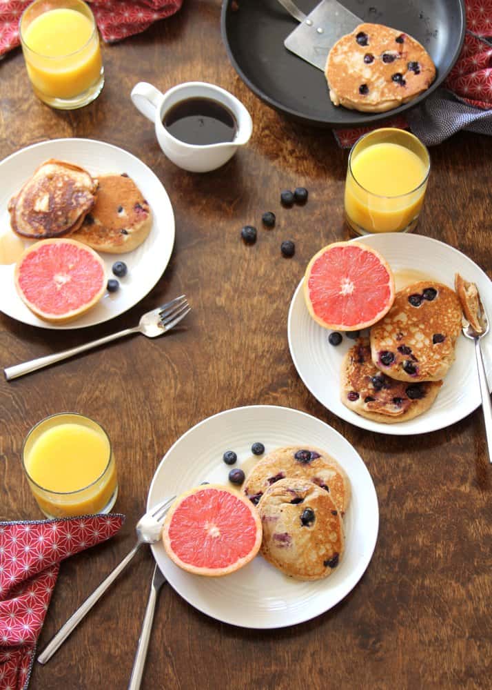 Blueberry Pancakes on white plates with grapefruit halves