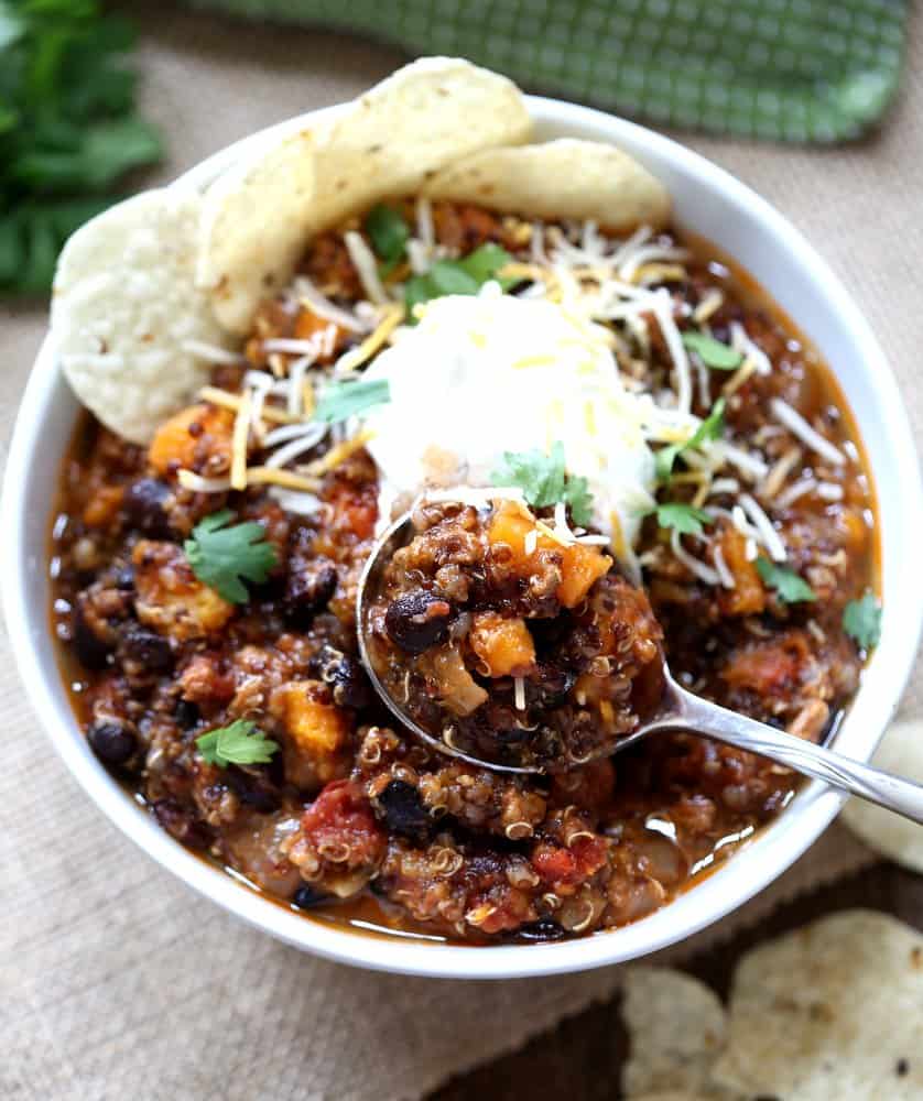 overhead image of a spoon scooping up turkey chili from a white bowl