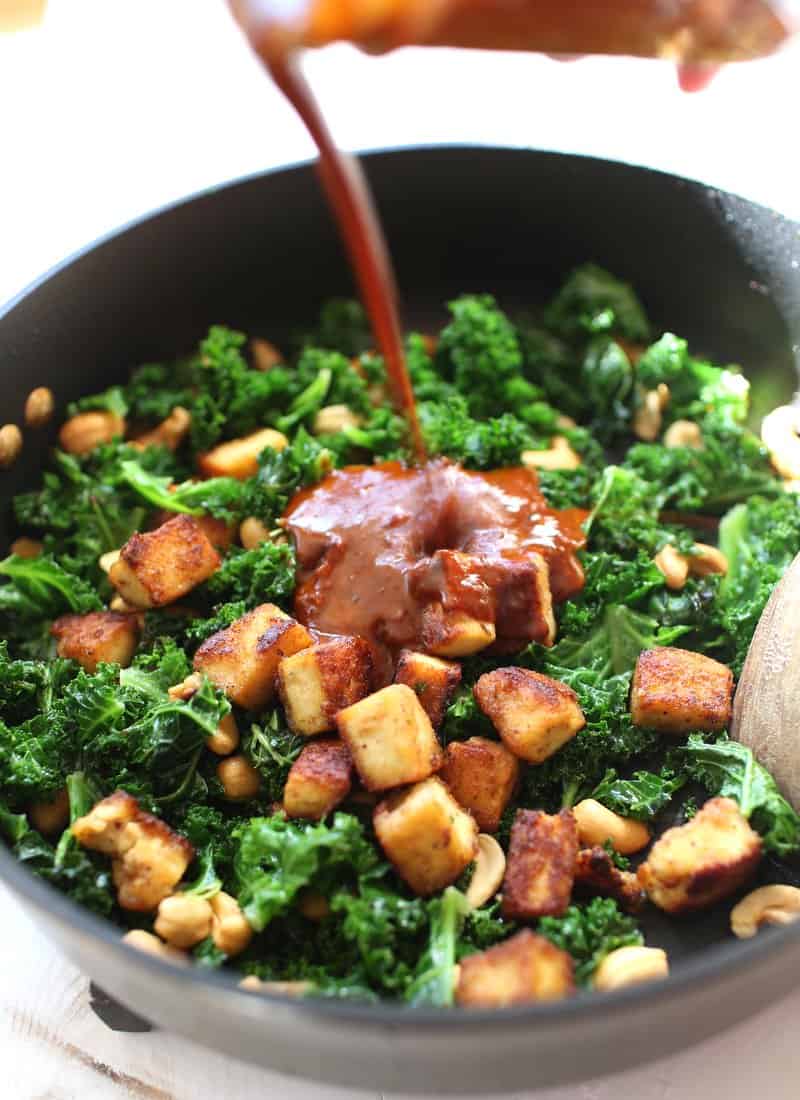 adding Thai chili paste to stir fry in a wok