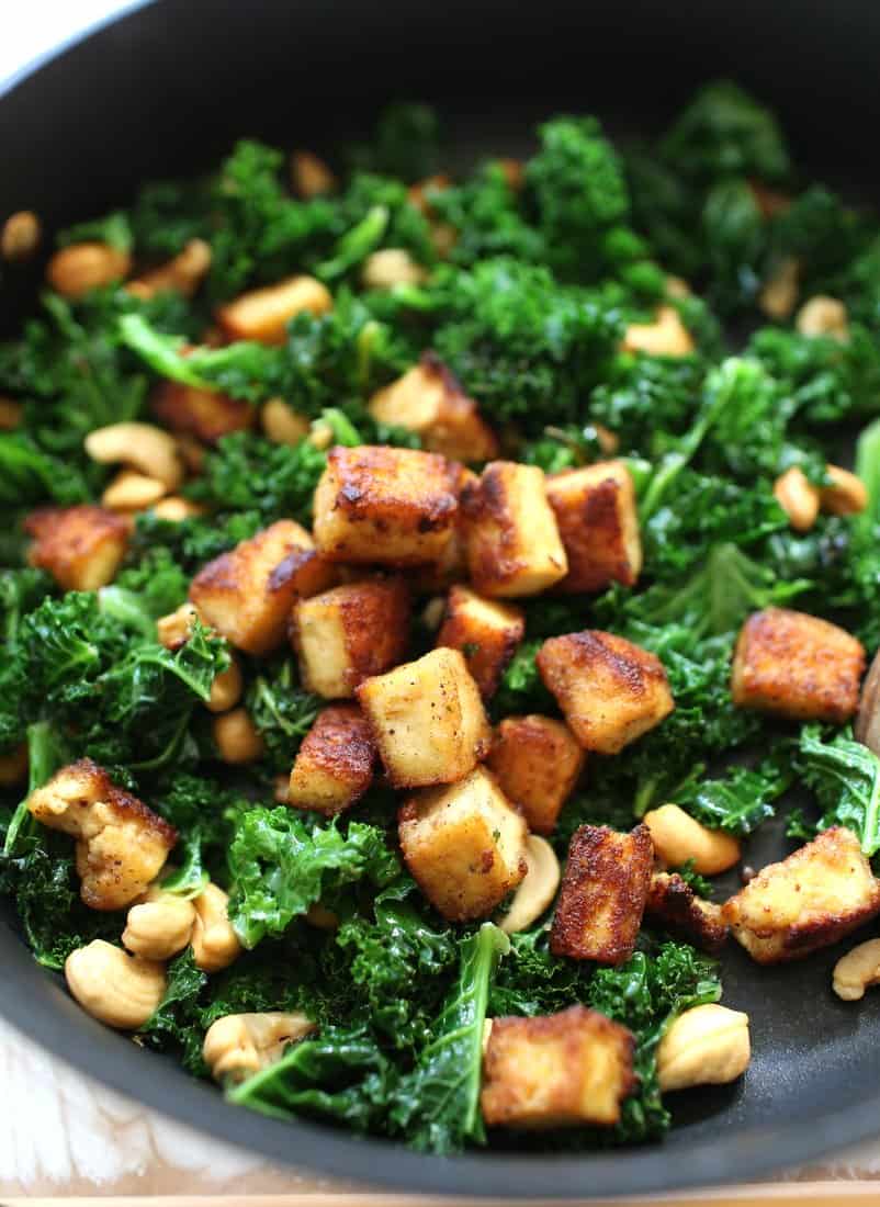 stir frying kale and tofu in a skillet