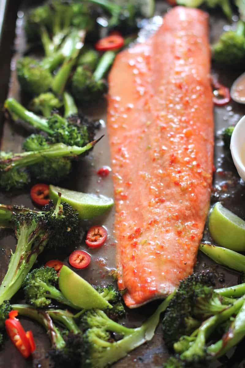 salmon, broccoli and lime wedges on a sheet pan