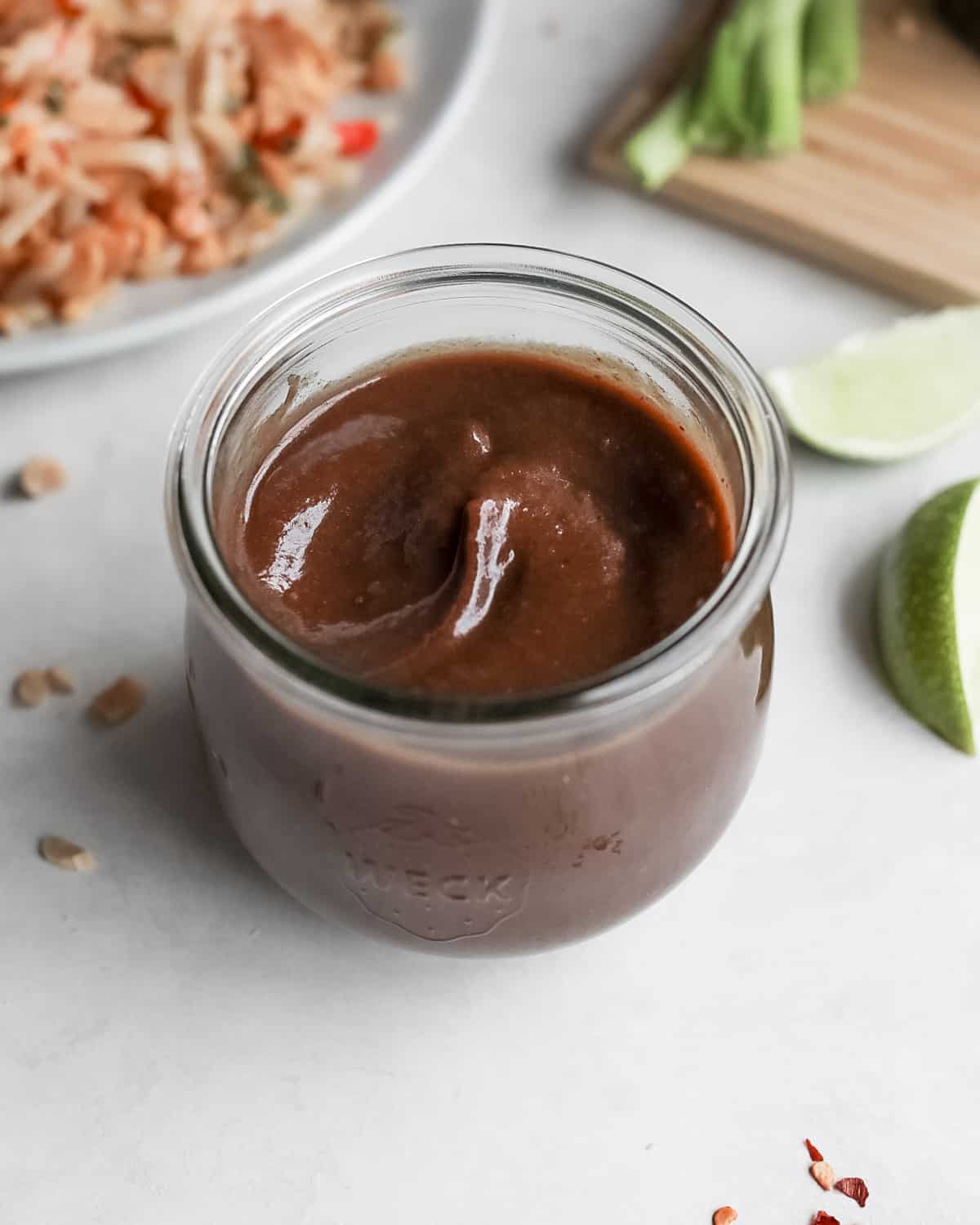 overhead image of tamarind paste in a Weck glass jar with pad thai in the background