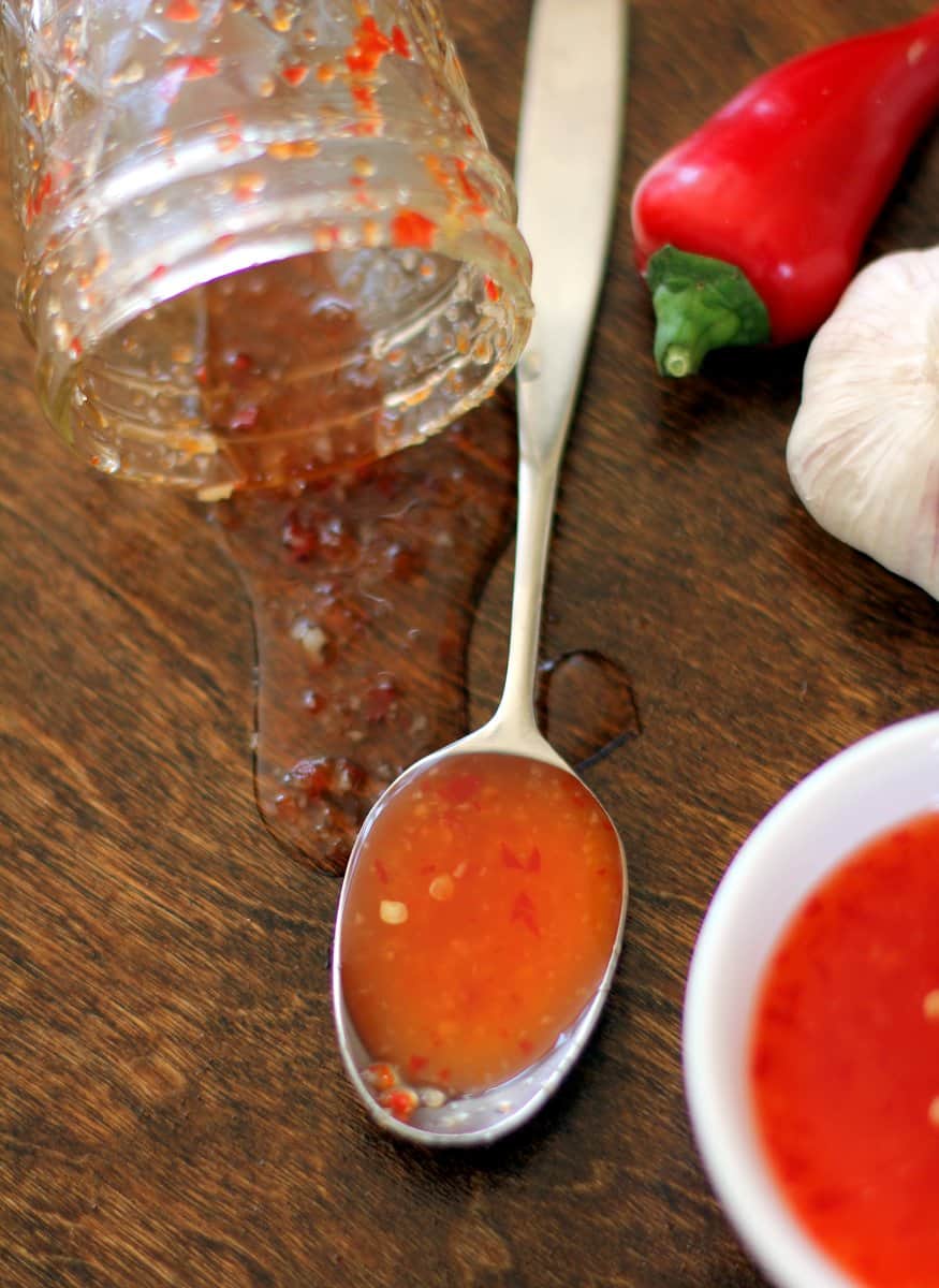 overhead image of a spoonful of Thai Sweet Chili Sauce on a wooden table