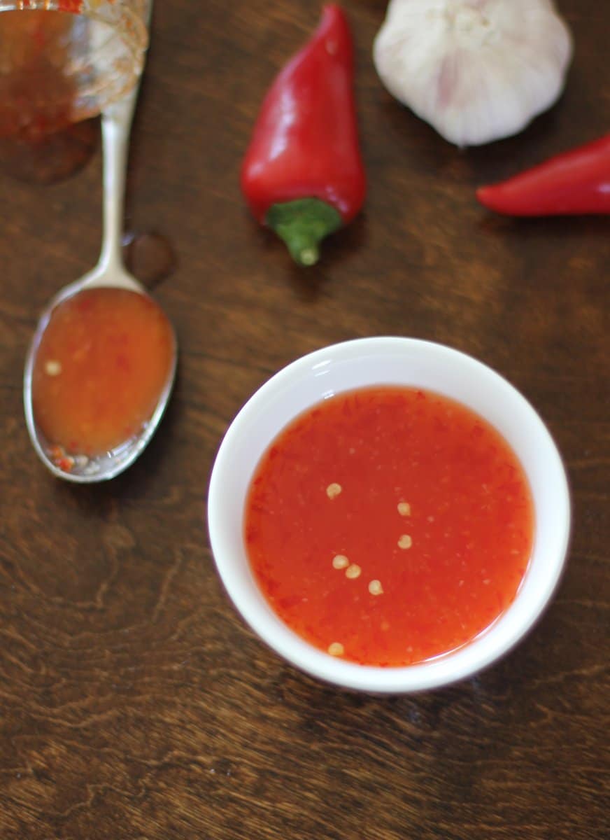 a small white bowl of thai chili sauce