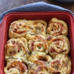 Baked ham and cheese rolls in a red baking dish