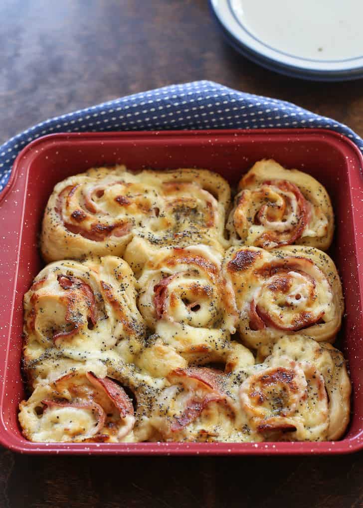 Baked Ham and Cheese Rolls in a red baking dish