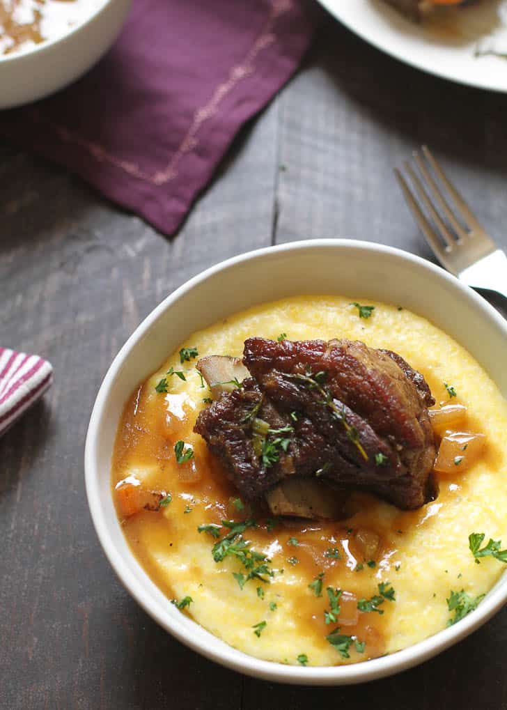 Braised Short Ribs over Parmesan Polenta in a white bowl