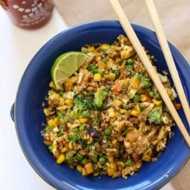 cauliflower fried rice in a blue bowl with chopsticks