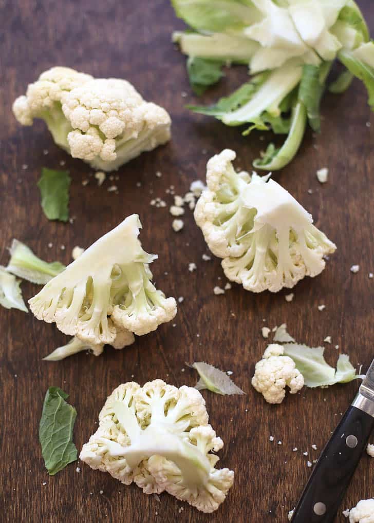 raw cauliflower florets on a wooden table