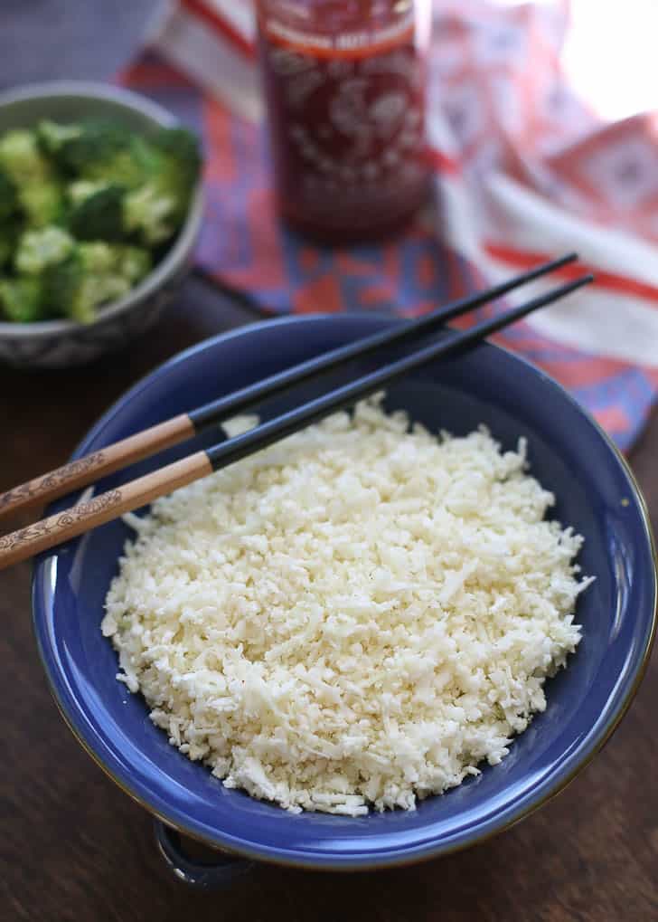 Cauliflower rice in a blue bowl with chopsticks