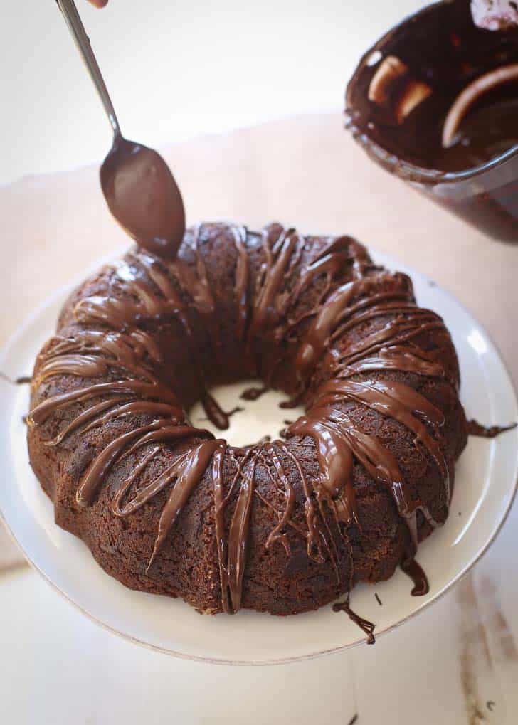 drizzling chocolate glaze over a Bundt Cake