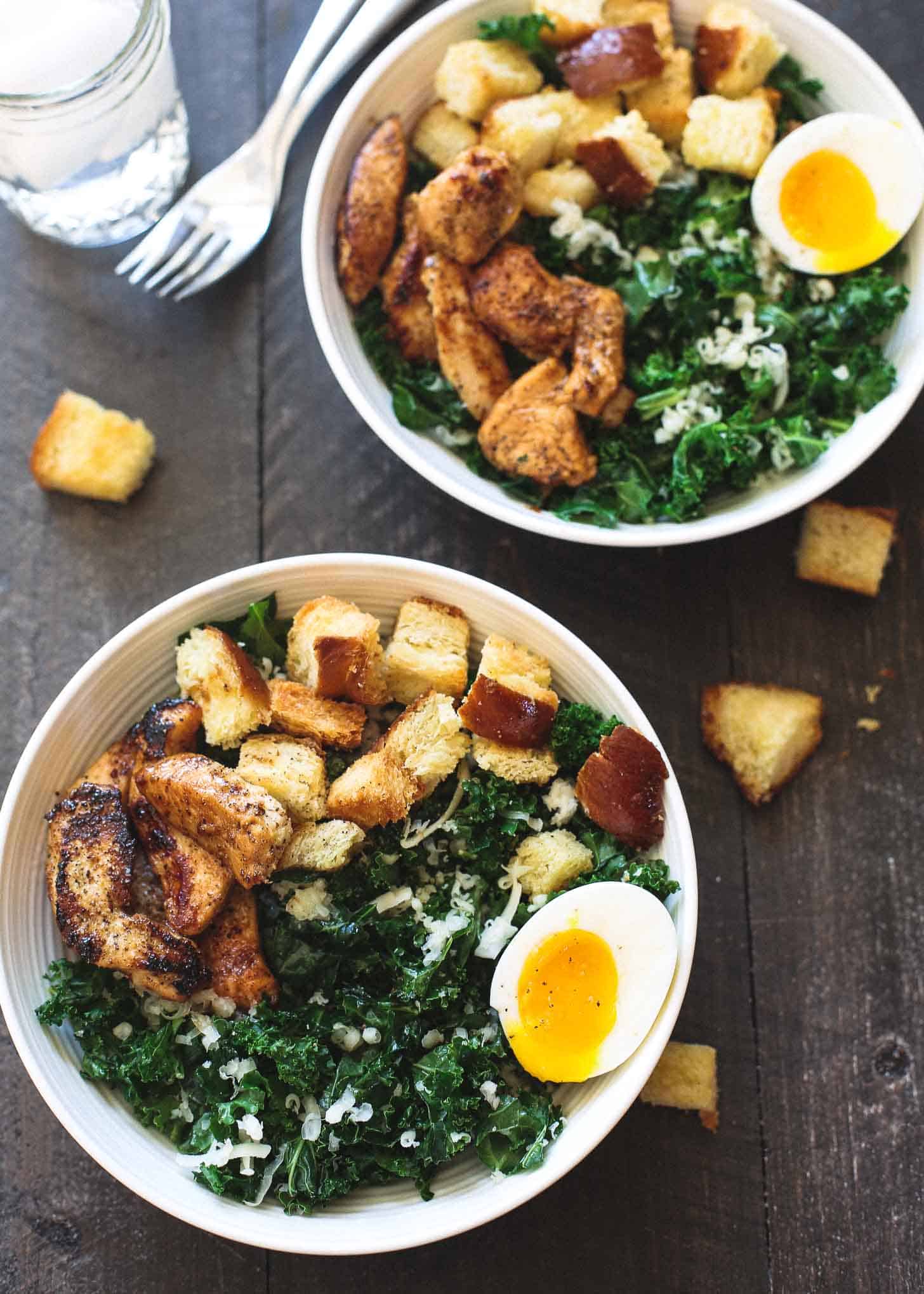 Kale Salad with Chicken and Soft Boiled Eggs in white bowls