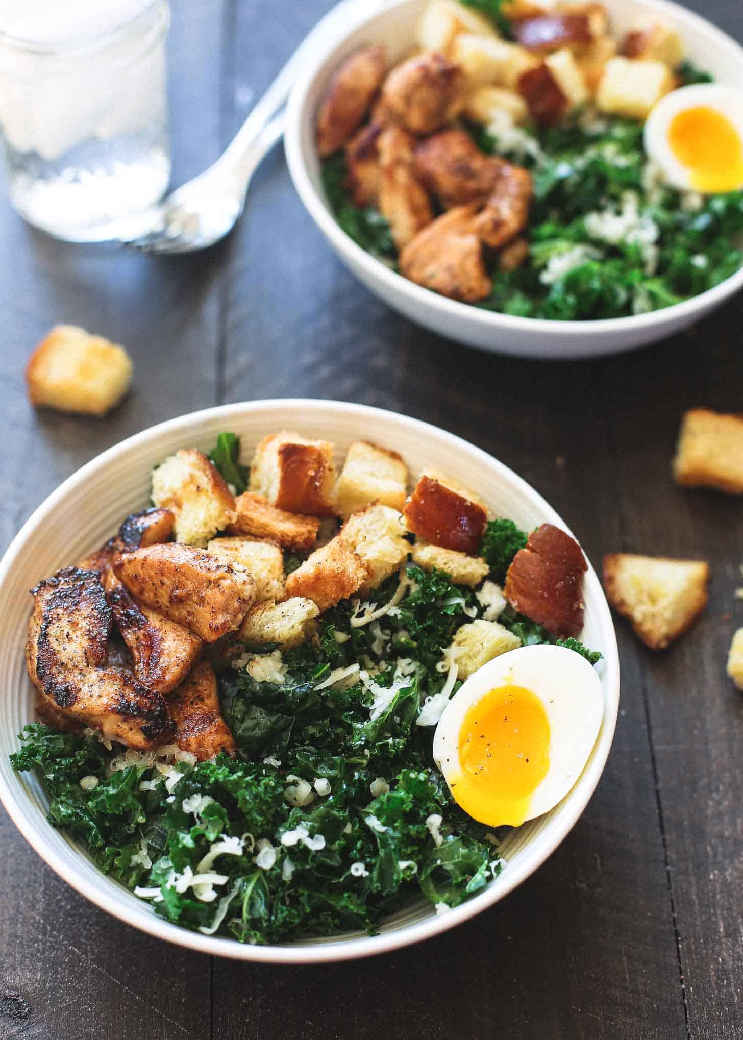 Kale Salad with chicken in white bowls on a wooden table