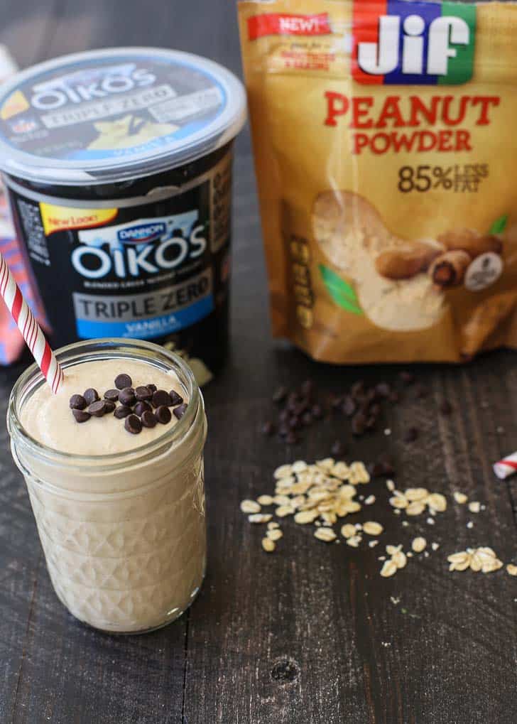 Peanut Butter Chocolate Oat Smoothie with yogurt and peanut powder on a wood table