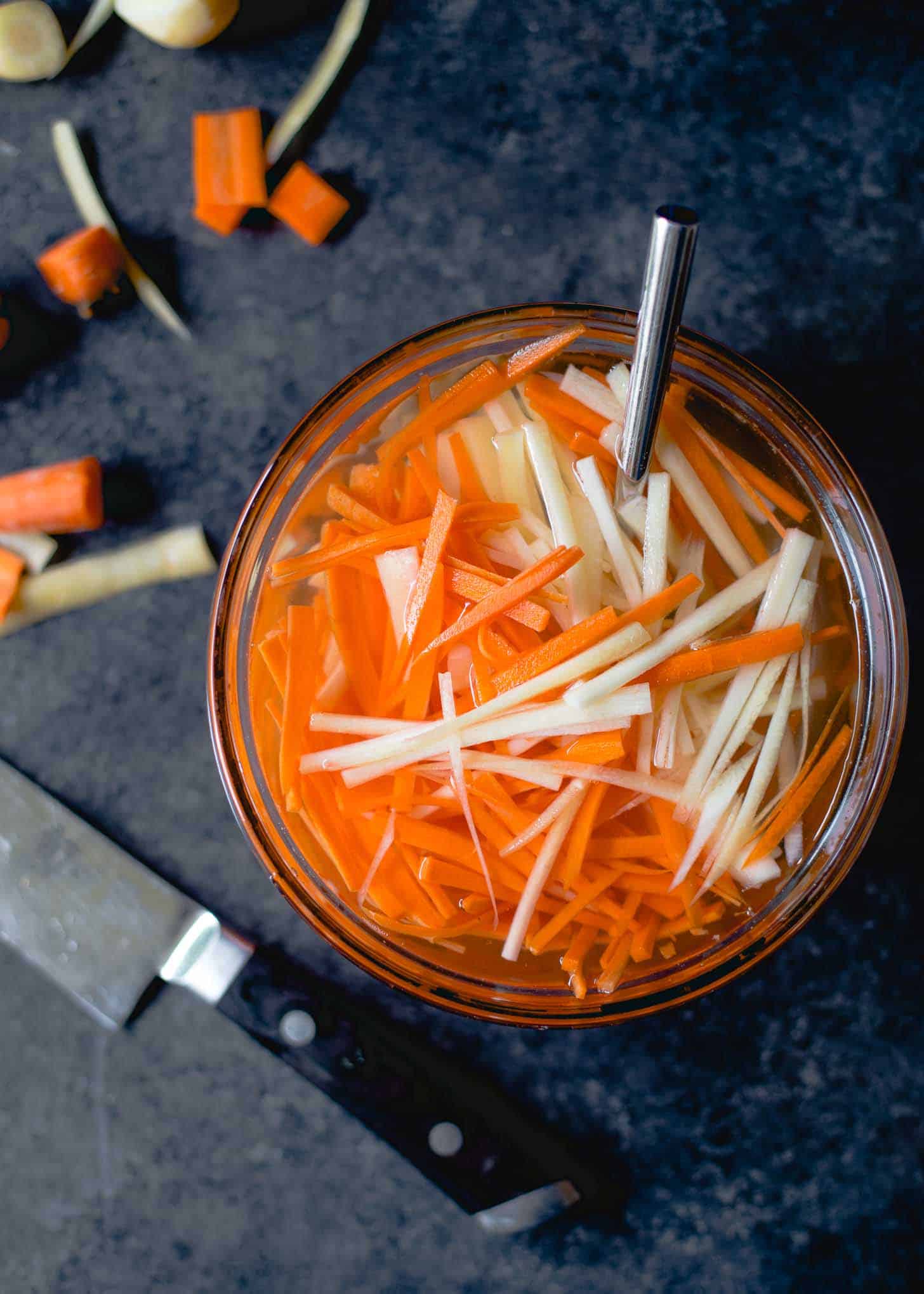 sliced carrots and Daikon radishes in a glass bowl