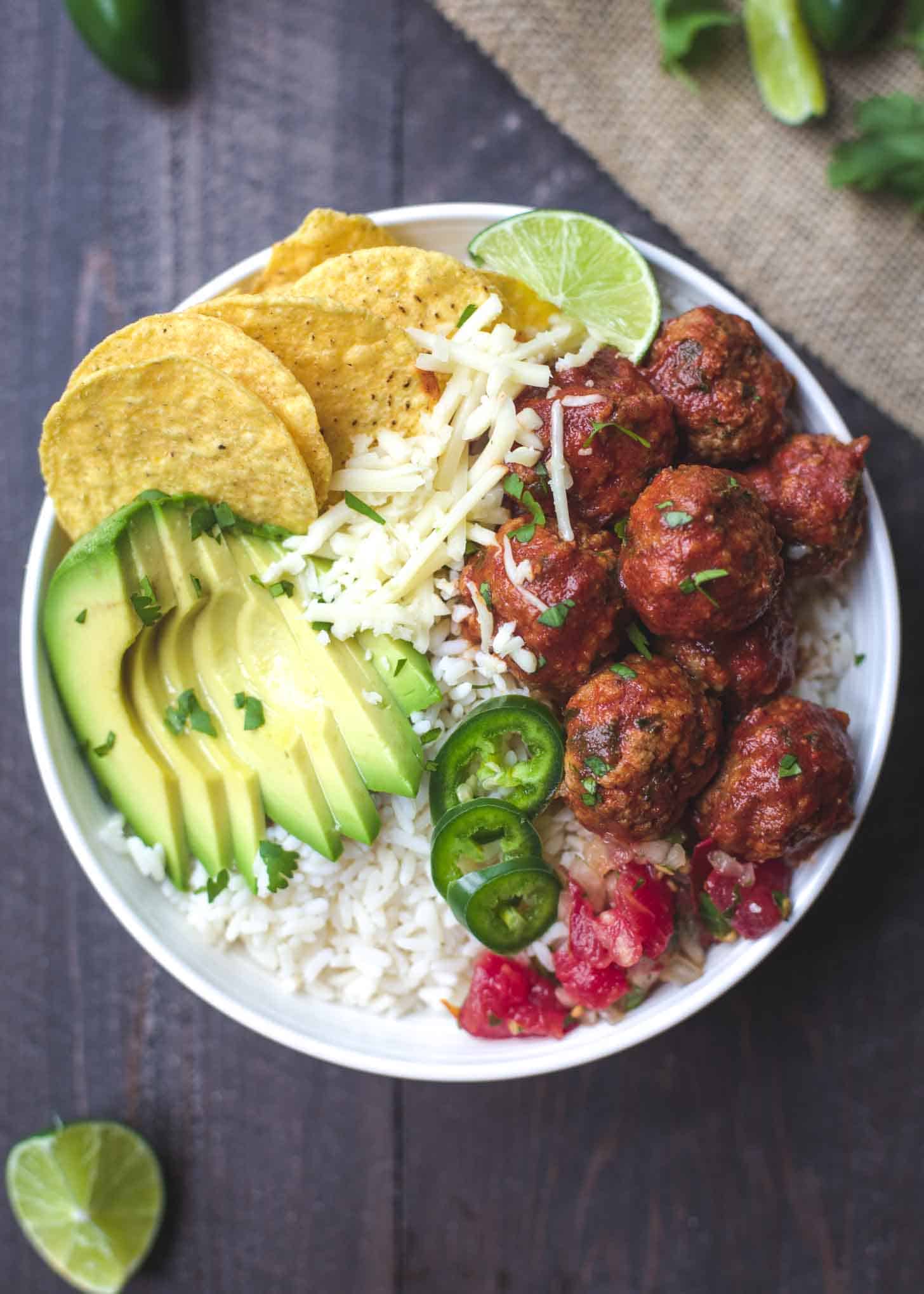 Taco meatballs over rice with avocado, cheese, jalapeno and chips