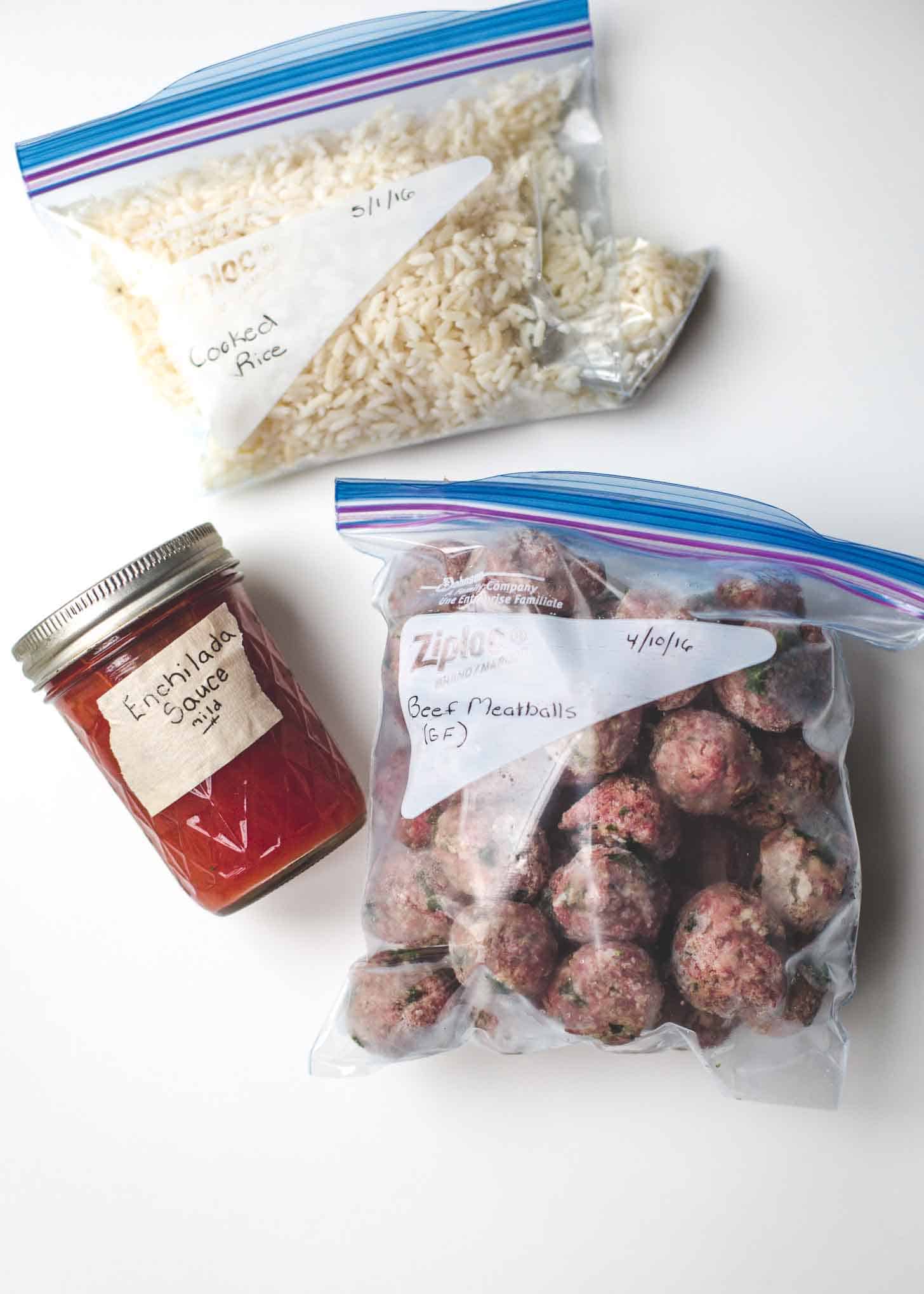 tacos, rice and enchilada sauce in storage containers