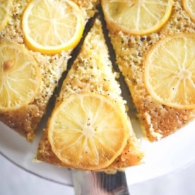 lemon olive oil cake on a white cake plate