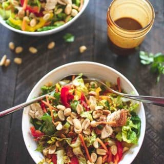 Thai Chopped Chicken Salad in a white bowl with salad tongs
