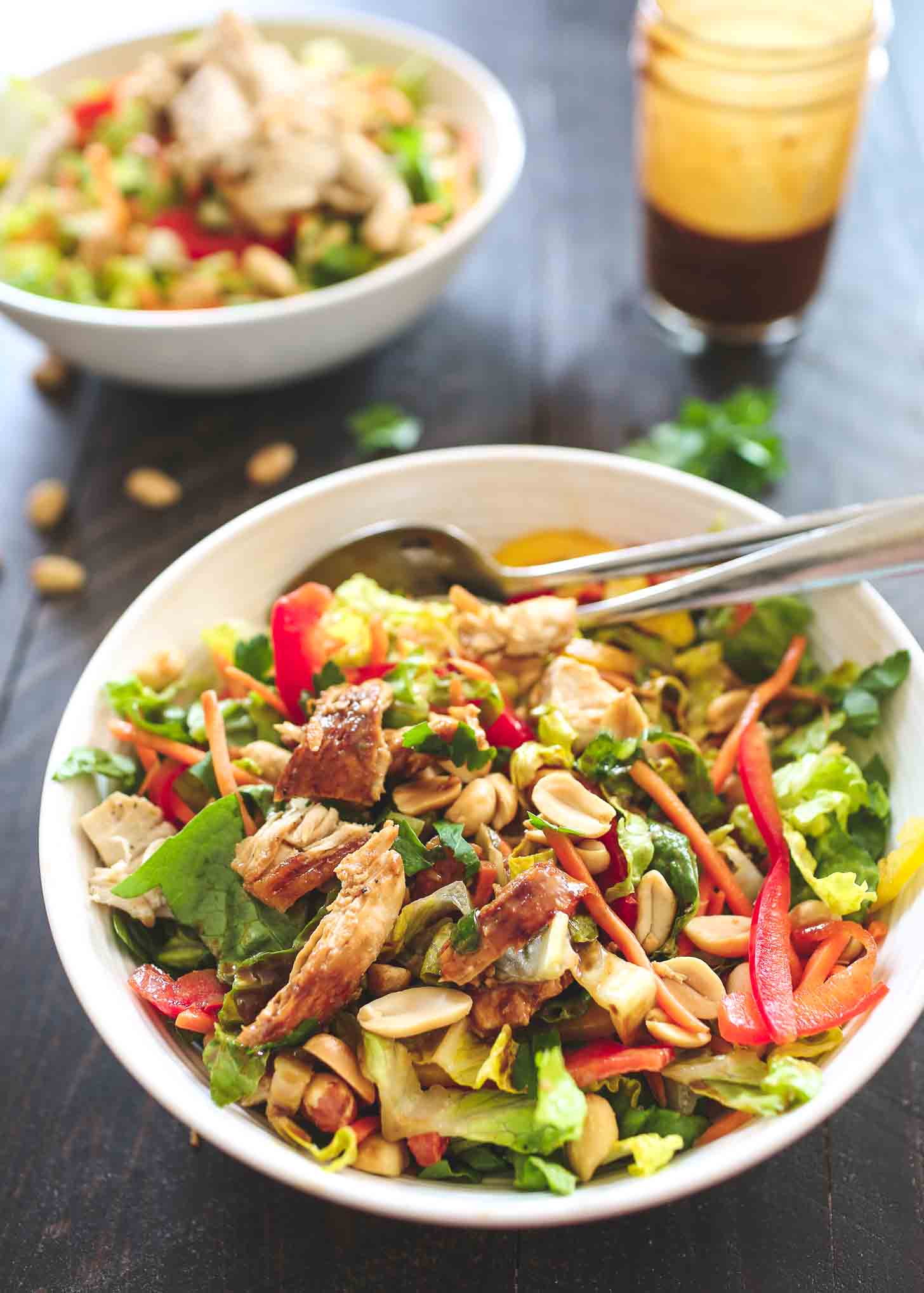 Chicken Salad in a white bowl with salad tongs