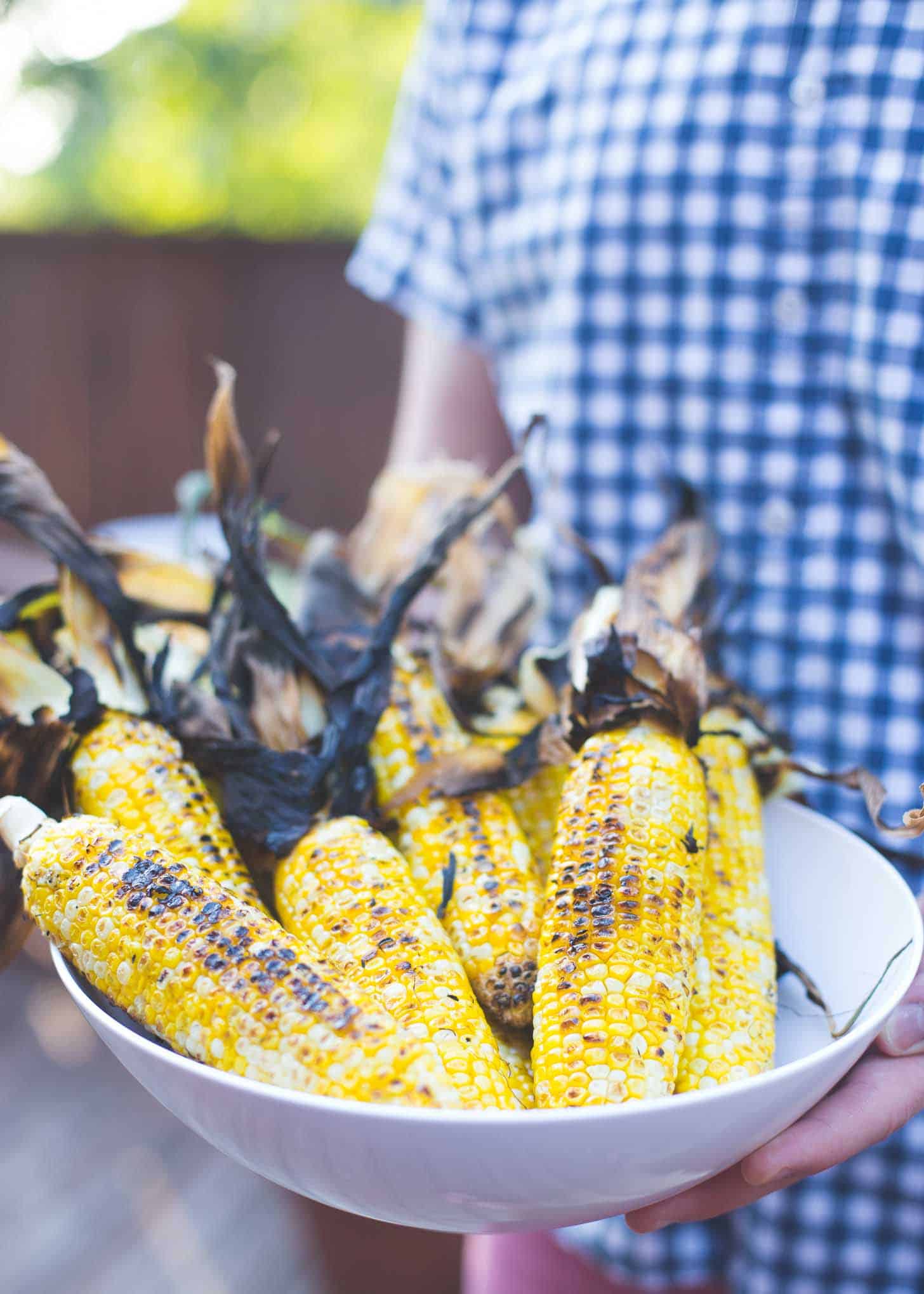 a white bowl of charred corn from the grill