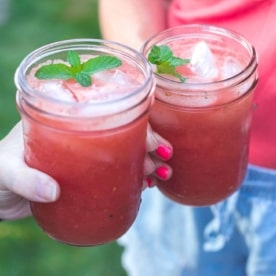 2 women's hands holding jars with watermelon lime cooler