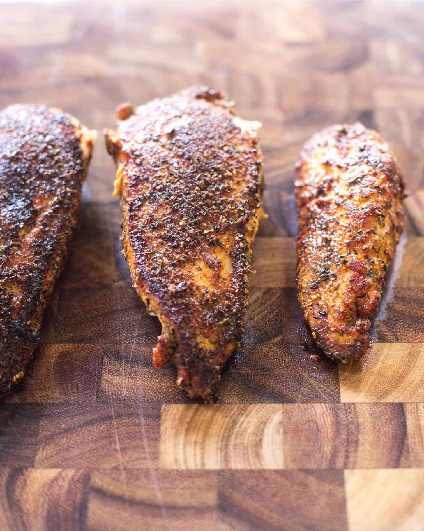 Caribbean Chicken breasts on a wooden cutting board