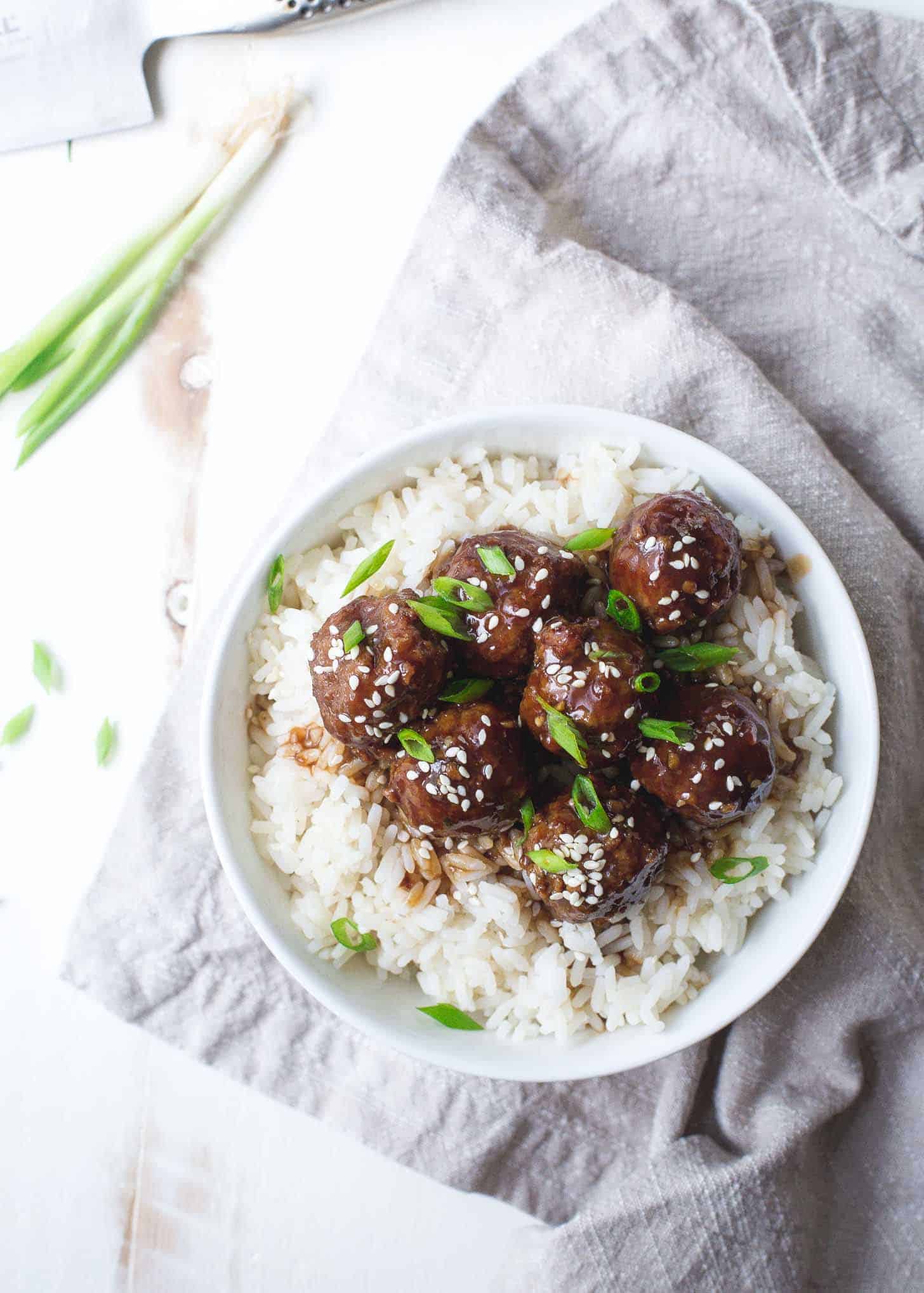 Meat over rice in a white bowl