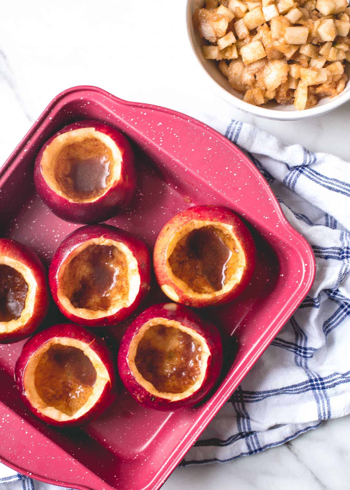 hollowed out Apples in a red baking dish