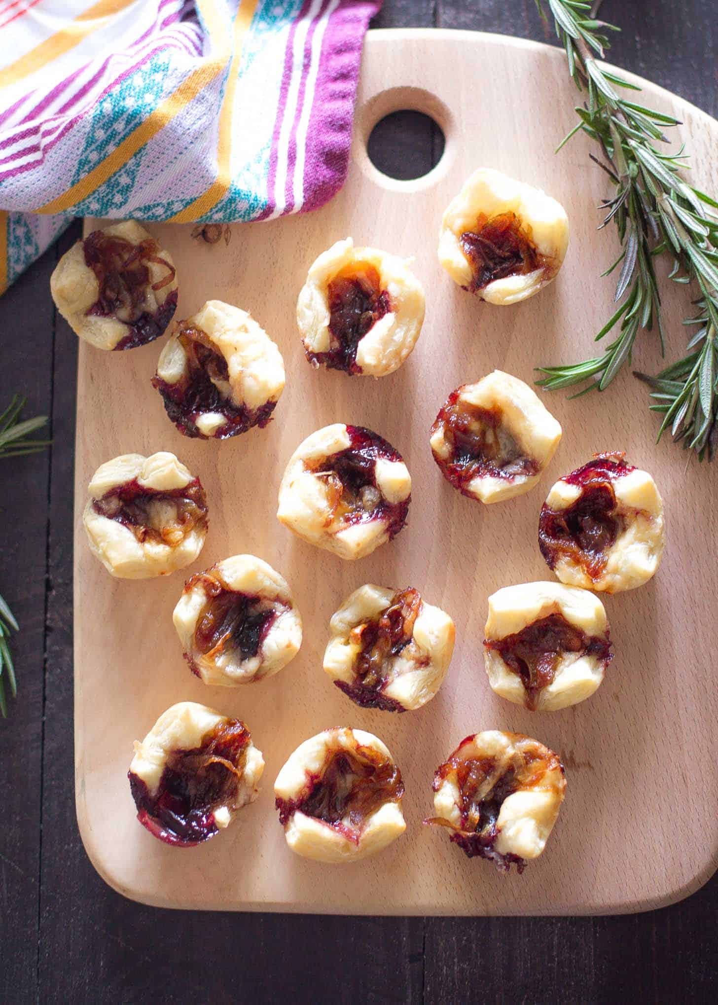 Savory Pastry Bites with Caramelized Onions and Gouda on a wooden tray