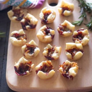 Savory Pastry Bites with Caramelized Onions and Gouda on a wooden tray