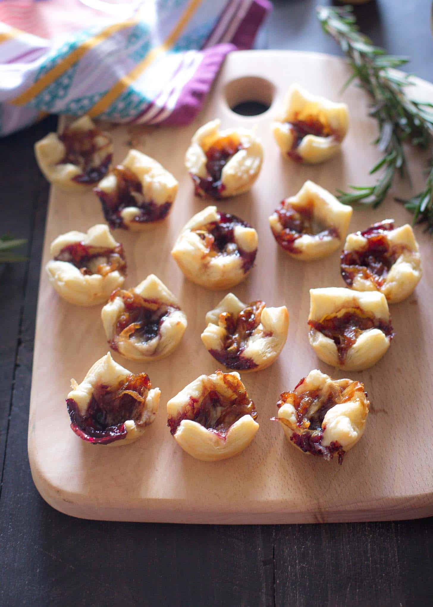 Puff Pastry Bites with Caramelized Onions and Gouda on a wooden tray