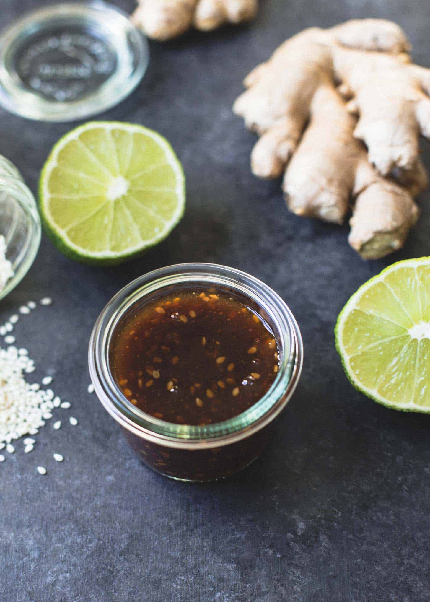 ginger, limes and sauce on a grey countertop