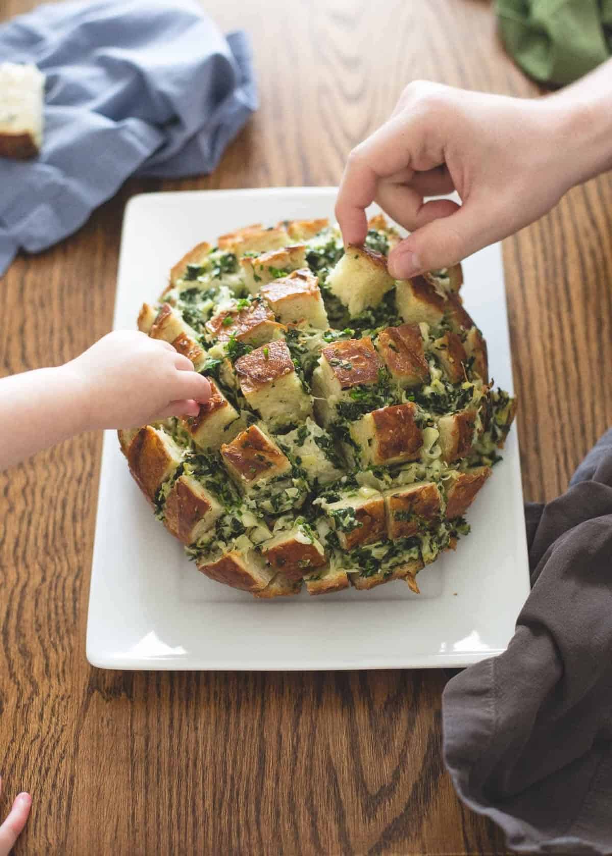pulling pieces off Pull Apart Bread