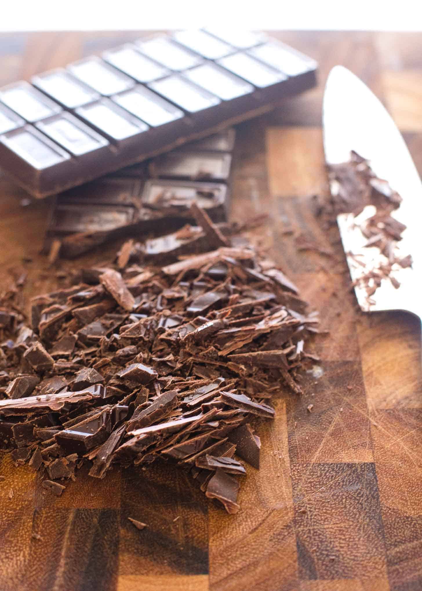 chopping a chocolate bar on a wooden cutting board