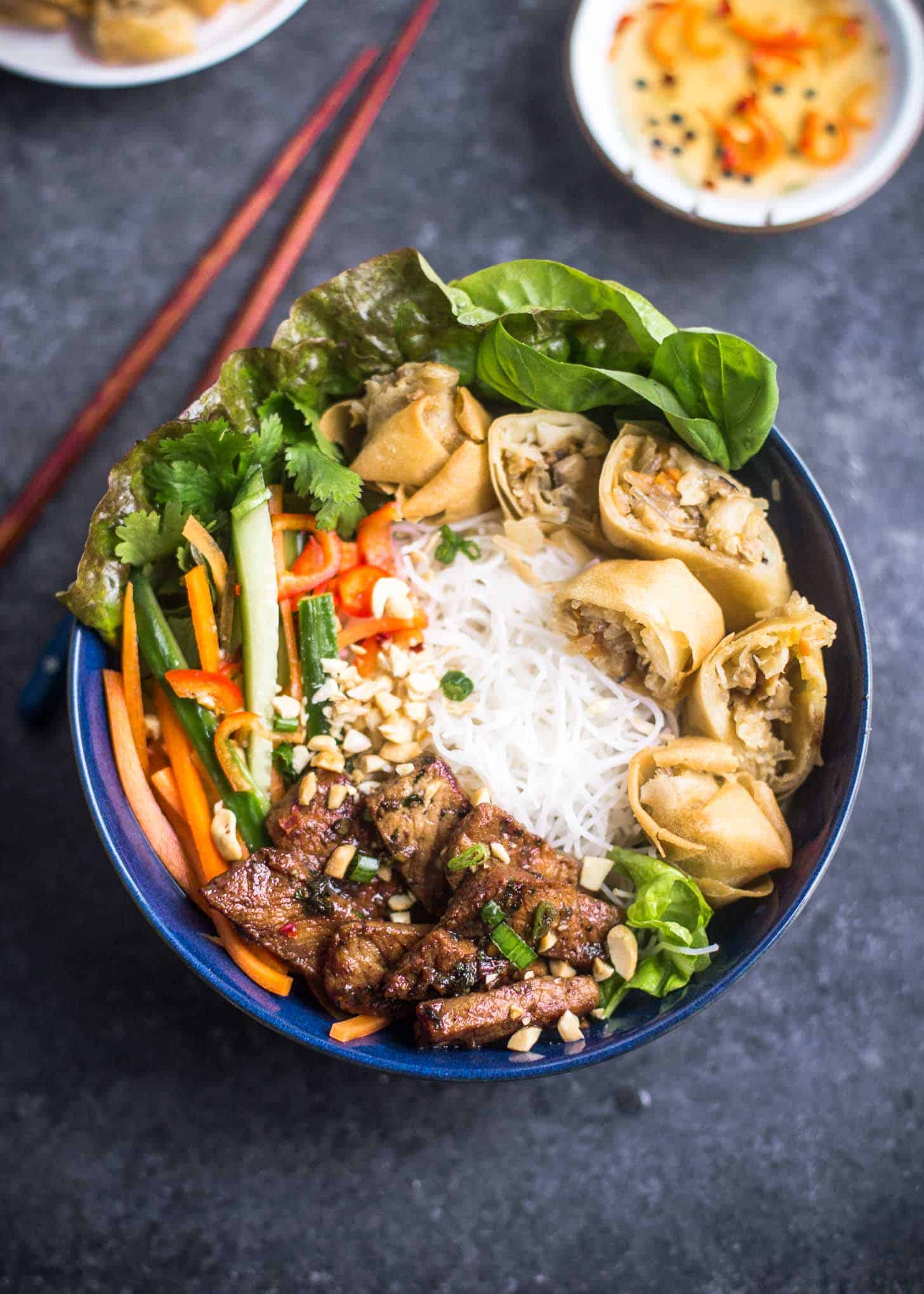 Vietnamese Noodle Bowls in a blue bowl next to chopsticks