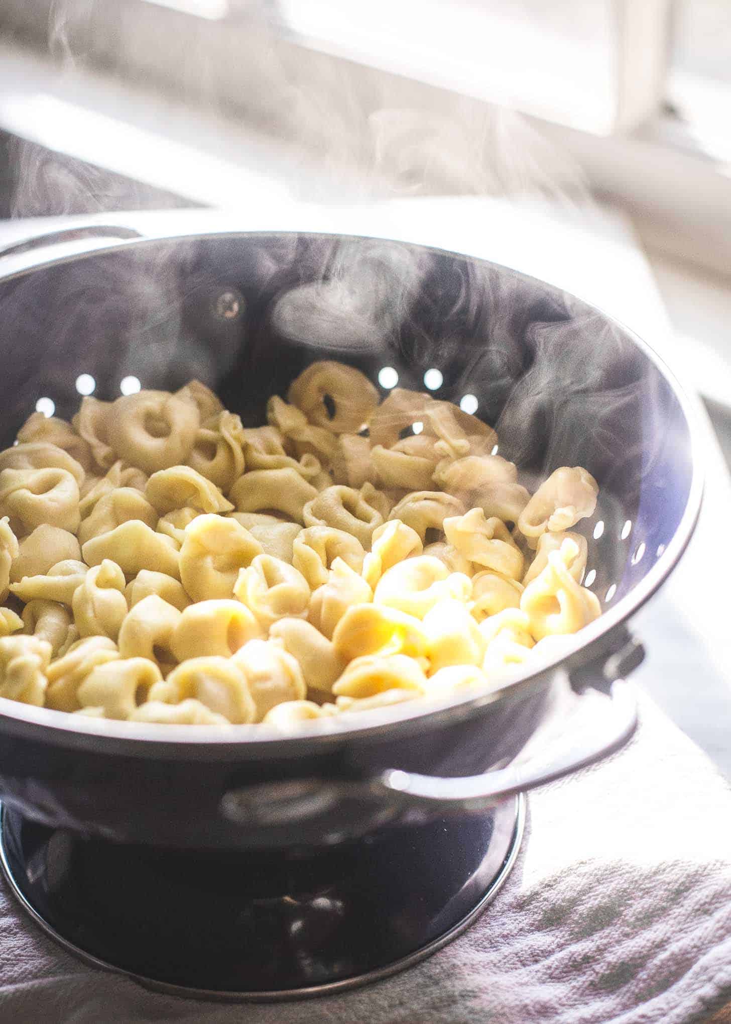 draining cooked tortellini in a colander