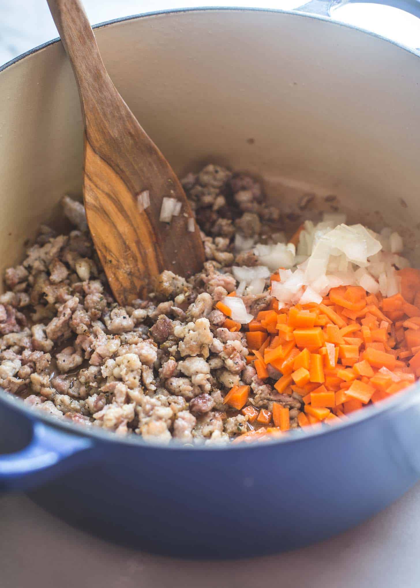 cooking sausage and vegetables in a dutch oven