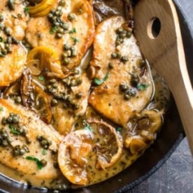 cooking chicken piccata in a cast iron skillet