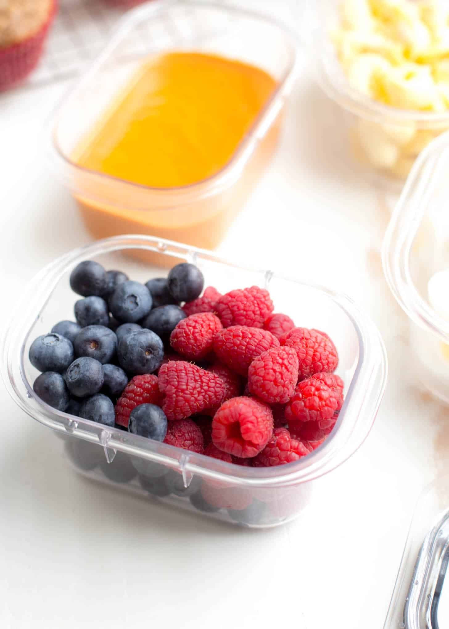 blueberries and raspberries in a plastic container