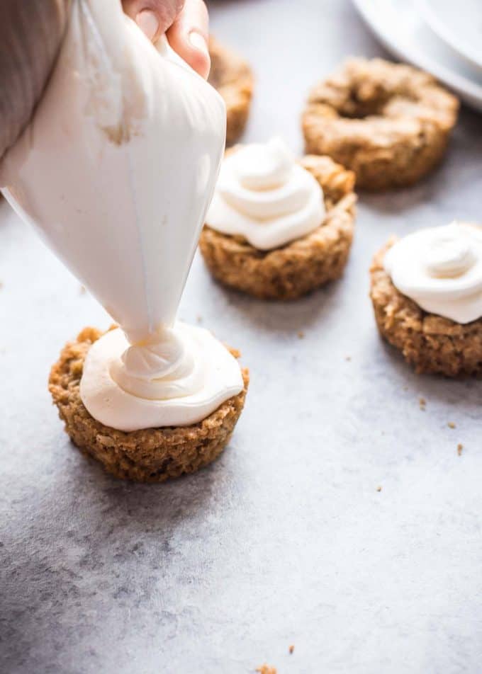 piping cream cheese icing on cookie cups