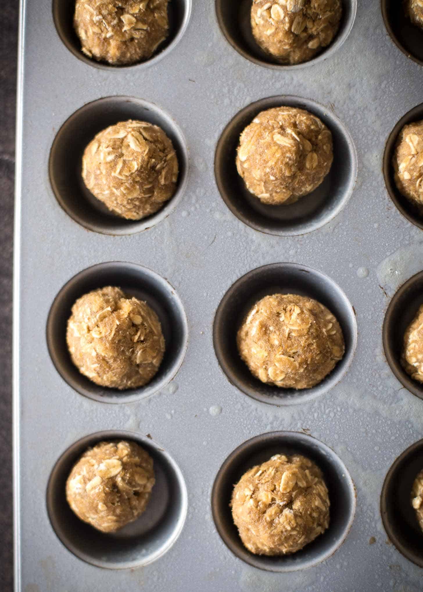 overhead image of uncooked oatmeal cookies in a mini muffin tin