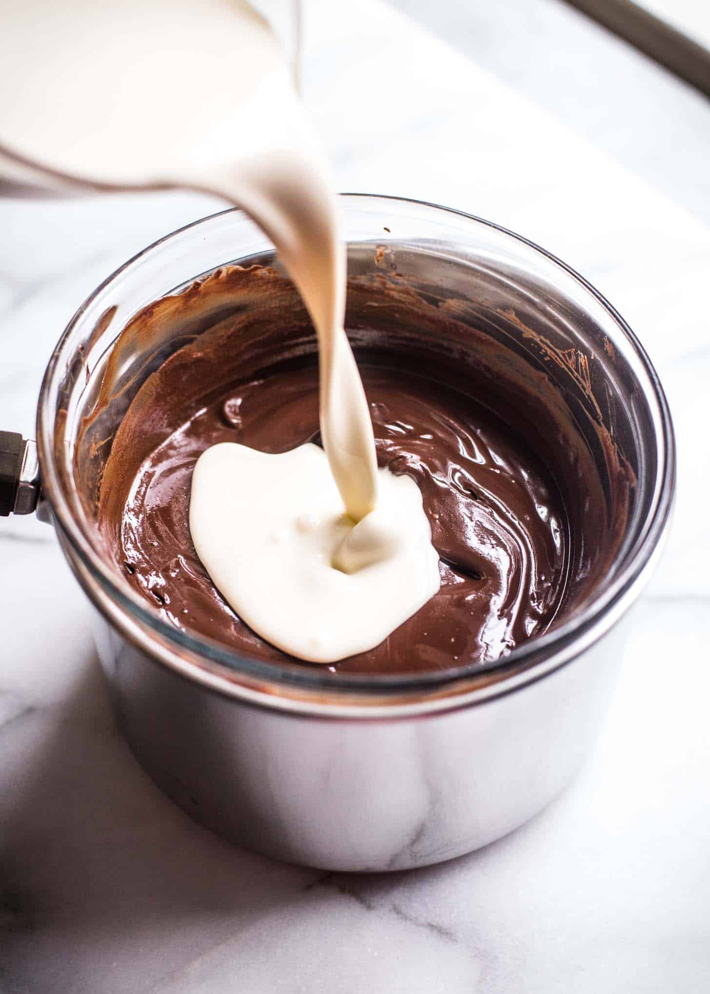 adding cream to chocolate over a double boiler