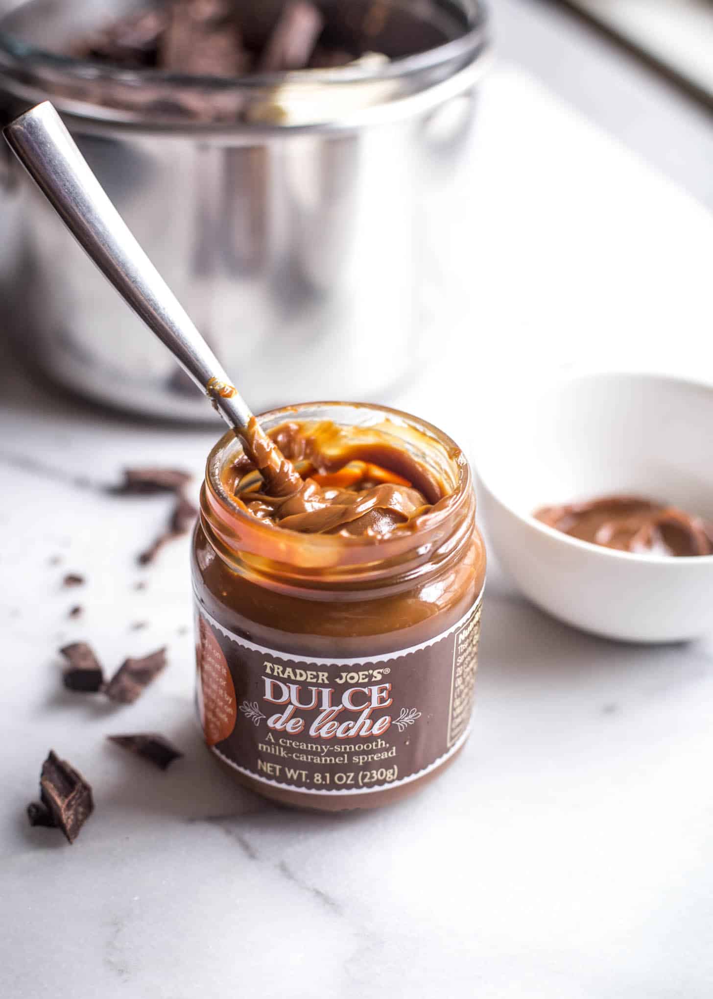 an open jar of dulce de leche with a spoon it it