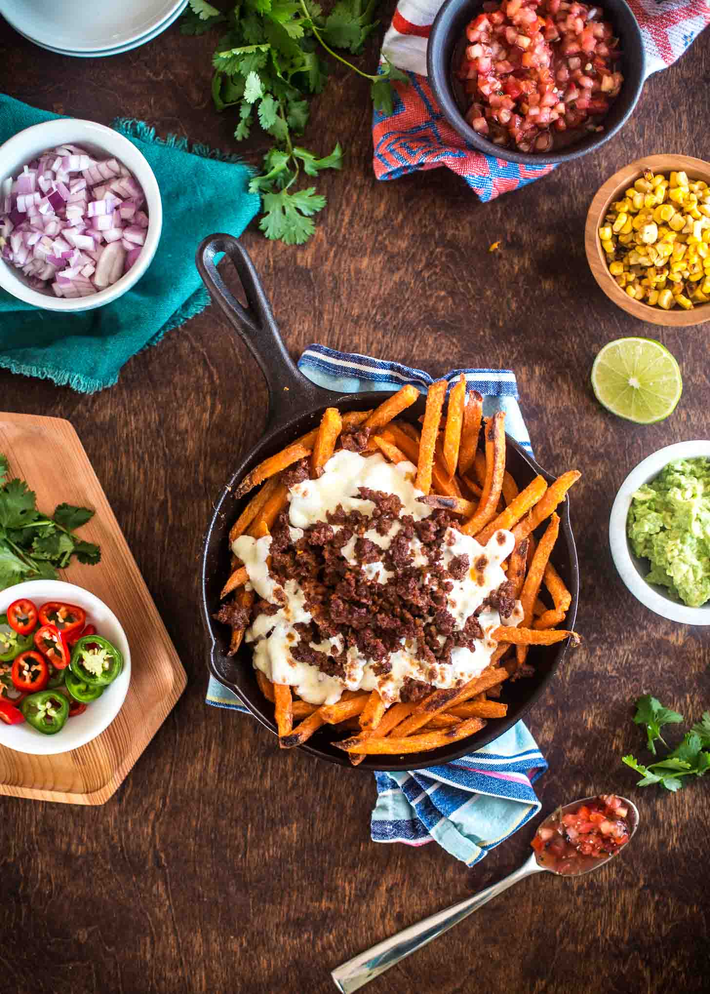 Sweet Potato Fries topped with cheese in a cast iron skillet