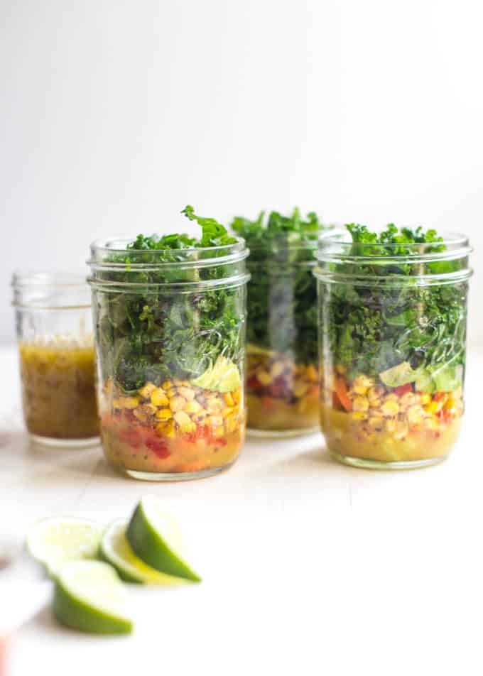 3 mason jar salads on a white table