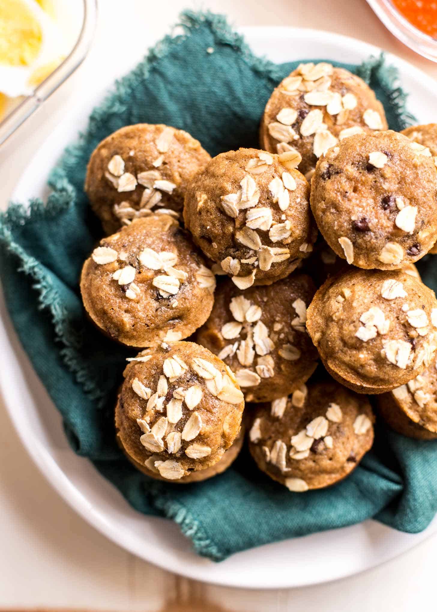 muffins in a white bowl lined with a blue towel