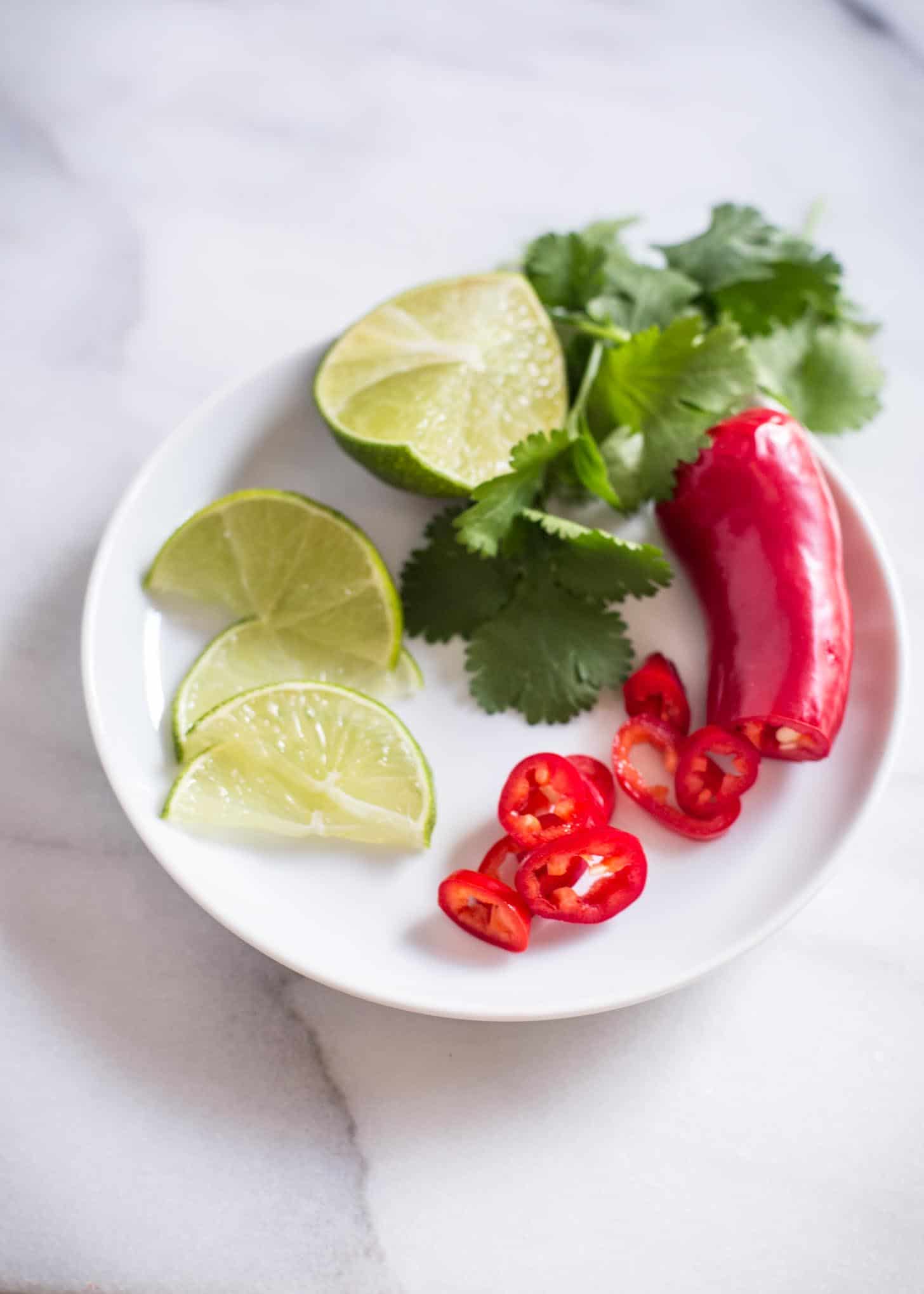 limes and peppers on a white plate